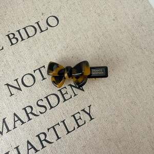 Detail of tortoise shell bow hair clip with FRANCE Handmade engraving on black resin