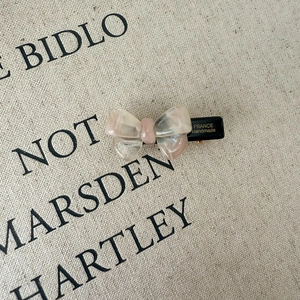 Detail of acetate bow hair clip with marble pattern and France Handmade engraving