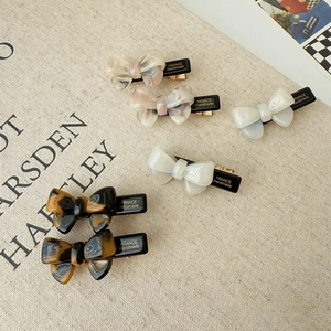 Elegant bow acetate hair clip set in tortoise, pink marble, and pearl white colors