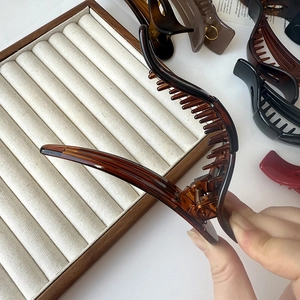 Dettaglio macro della grande pinza per capelli tartaruga ambra con molla in metallo