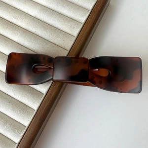 Dettaglio macro della grande clip per capelli a fiocco con finitura tartaruga