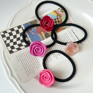 Elegant set of four rose-shaped elastic hair ties in various shades of pink and red