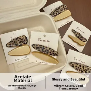 Detail view of acetate tortoise shell and beige hair clips in eco-friendly packaging