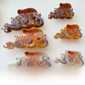 Detailed view of six acetate octopus hair claws with amber base and blue polka dots