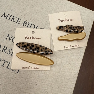 Detailed macro view of tortoiseshell acetate hair clips on a professional display card