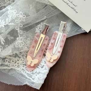 Detail of pink marble acetate hair clips with crystal rhinestones and cream butterflies