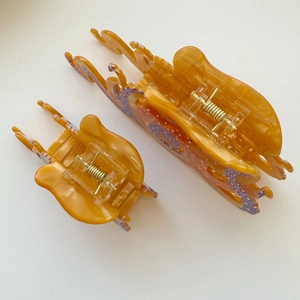 Detail of octopus hair claws in amber orange acetate with purple dots and gold springs