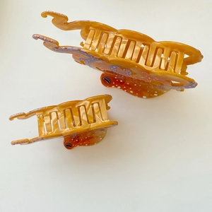 Detailed macro view of orange octopus hair claws with marble texture and dotted pattern