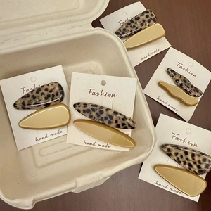 Leopard pattern and yellow acetate hair clips set displayed on white cards