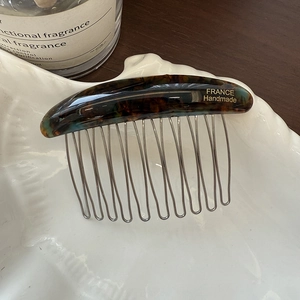 Close-up of handmade tortoise shell acetate hair comb with golden France lettering