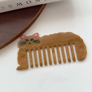 Detail of cute cat-shaped hair comb made of premium brown marble acetate with gold accents