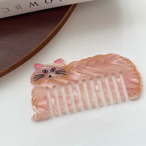 Close-up of pink marble pattern acetate cat hair comb with golden fine line details