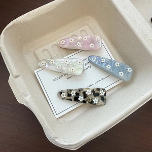 Set of four floral acetate hair clips in pink, blue, white, and tortoiseshell patterns