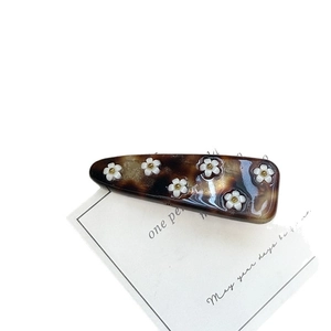 Tortoiseshell floral acetate hair clip with white resin flowers and golden beads