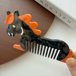 Détail macro du peigne en acétate en forme de cheval avec texture marbrée et orange