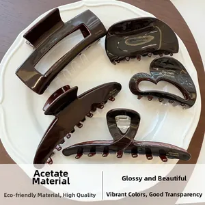 Close-up of gloss amber acetate hair claw set featuring five geometric styles on a ceramic tray