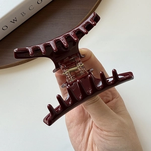 Close-up of wine red acetate hair claw clip with glossy finish and durable metal spring