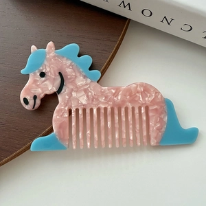 Gros plan d'un peigne en acétate en forme de cheval avec motifs floraux roses et bleu ciel