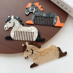 Trois peignes à cheveux en forme de cheval en acétate marbré sur un plateau en bois