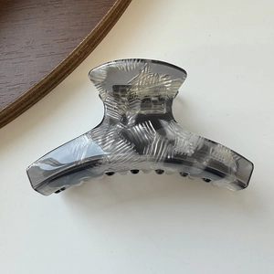 Detail of translucent marble pattern hair claw clip in elegant smoky gray finish