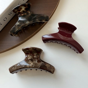 Three-piece set of elegant acetate hair claws in tortoiseshell, burgundy, and marbled patterns