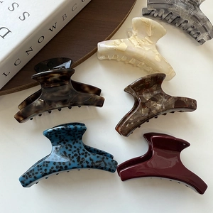 Set of small acetate hair claw clips in marble, tortoiseshell, and solid color finishes