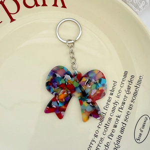 Détail macro du porte-clés nœud en acétate coloré avec texture mosaïque et anneau argenté