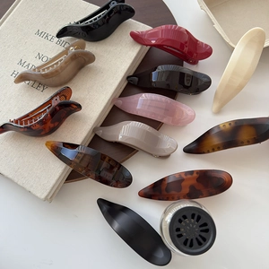 Detailed close-up of premium resin hair clips in various colors on a linen surface