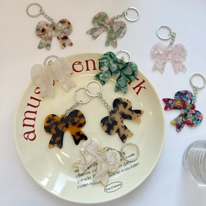 Porte-clés nœud papillon en acétate aux motifs marbrés et écailles avec anneaux en métal
