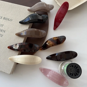 Minimalist glossy resin hair clip set in various colors on a stylish wooden tray