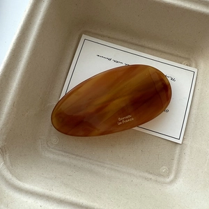 Detailed view of an oval tortoiseshell acetate hair clip with Barrette La France engraving