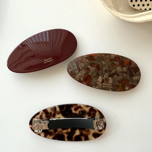 Three-piece set of oval acetate hair barrettes in solid red, marble, and tortoise patterns