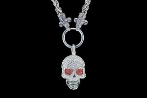 Macro detail of gothic skull pendant with red eyes and byzantine chain link