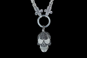 Macro shot of gothic ram head connector and skull pendant with black and white zircons