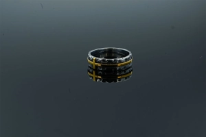 Macro d'une bague punk en acier inoxydable avec texture martelée vintage et croix dorée
