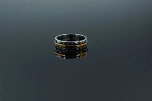 Vue détaillée de la bague rétro en acier inoxydable avec croix dorée et texture de lave