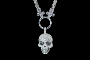 Close-up of gothic skull pendant with inlaid stones and detailed ram head link chain