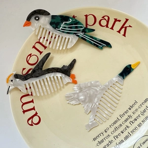 Three cute animal shaped acetate hair combs featuring colorful bird and lobster designs