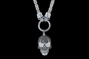 Macro shot of punk gothic skull pendant with pave crystals on thick Byzantine chain