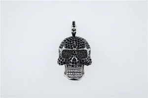 Gros plan du pendentif crâne style punk en argent avec sertissage de zircons noirs