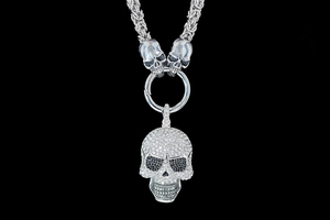 Macro shot of a punk skull pendant with crystal rhinestones on a heavy silver chain link