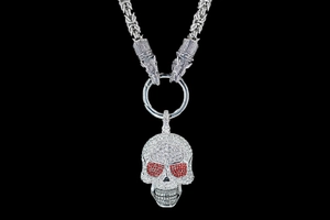 Détail du collier tête de mort gothique avec yeux en cristaux rouges et maillons tête de loup