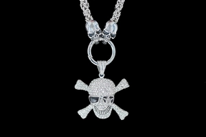 Close-up of punk skull pendant with rhinestones and black sunglasses on a thick metal chain