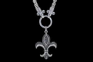 Detailed macro view of silver ram head motifs and fleur-de-lis pendant with black stones