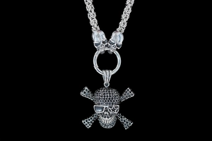 Macro shot of a punk skull pendant with black rhinestones on a thick silver-black chain