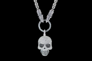 Vue macro du pendentif crâne orné de cristaux avec fermoirs tête de loup sur chaîne