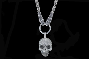 Makro-Detail von Punk-Totenkopf-Anhänger mit weißen Strasssteinen und Silberdrachen-Motiven