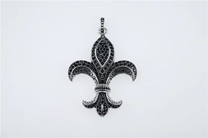 Détail macro du pendentif fleur de lys gothique avec des cristaux noirs incrustés