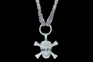 Makroaufnahme von Totenkopf-Lilien-Anhänger mit Diamanten und Schlangenkopfkette