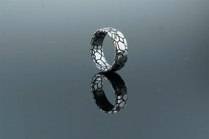 Macro shot of silver ring with geometric hexagonal texture and clean mirror reflection